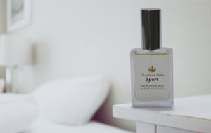 Das Exklusive Parfum perfume bottle on table in front of soft-focus bed